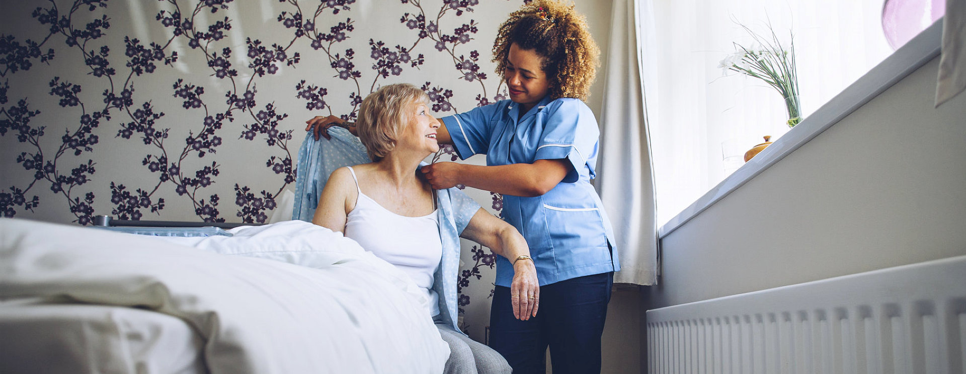 caregiver helping senior dress up