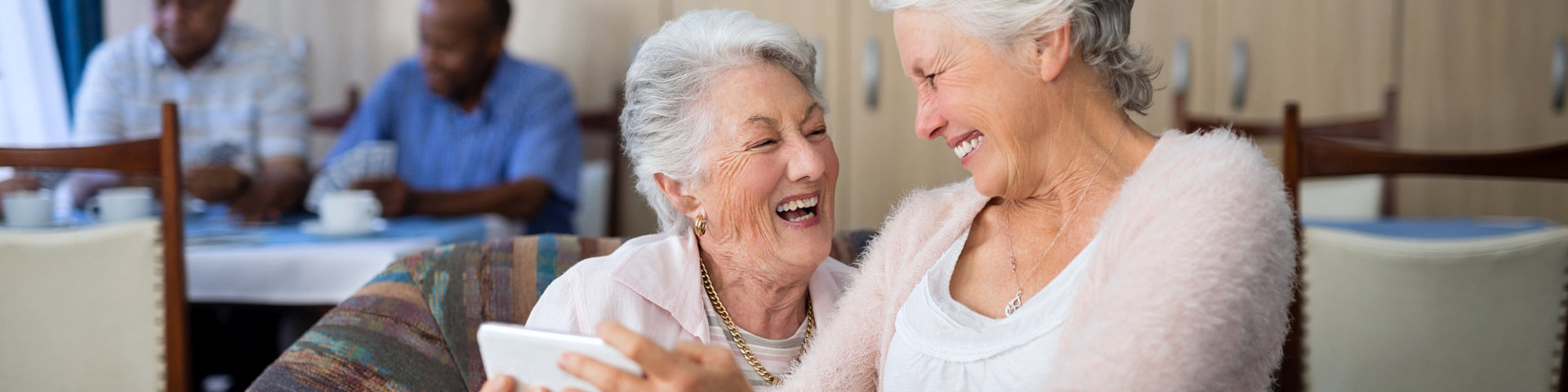 two senior women smiling at each other