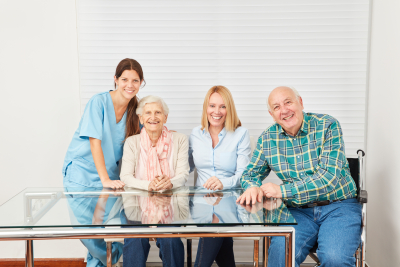 caregiver with senior woman, woman and senior man smiling