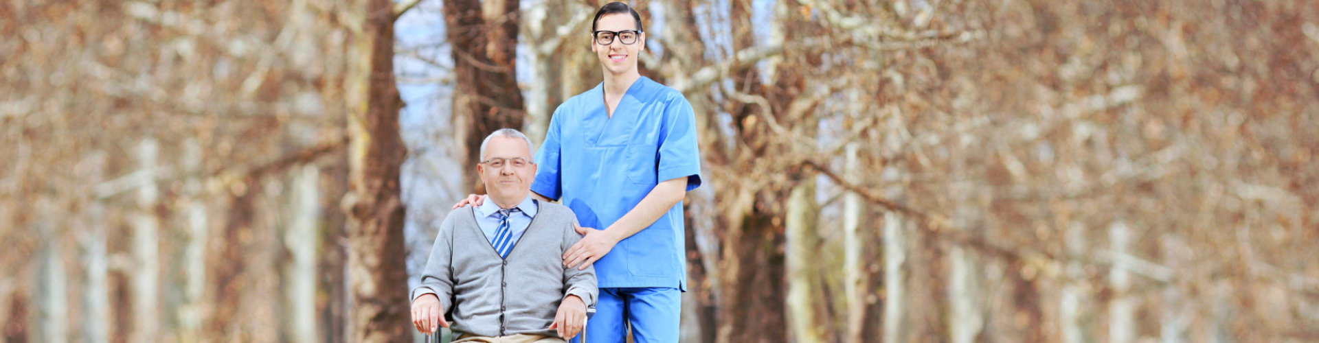 senior man in wheelchair smiling with caregiver