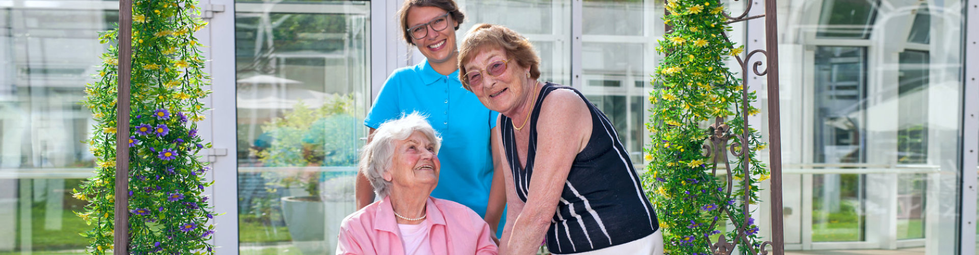 two senior woman smiling with caregiver