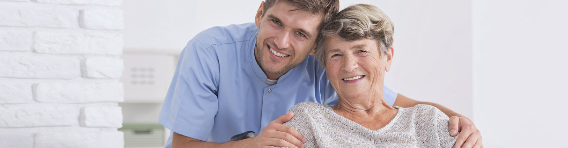 male caregiver with senior woman smiling